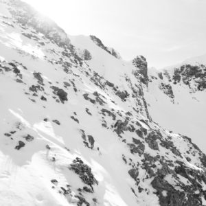 Snow-covered rocky mountain range under bright sunlight